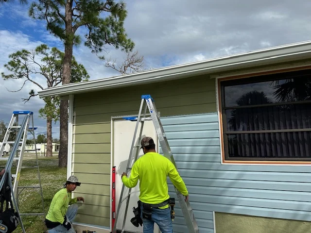RFH crew installing vinyl siding on a Clearwater mobile home